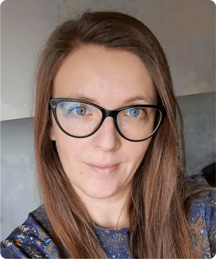 Uśmiechnięta kobieta w okularach we wzorzystej bluzce, korektorka Słowa Klucze.